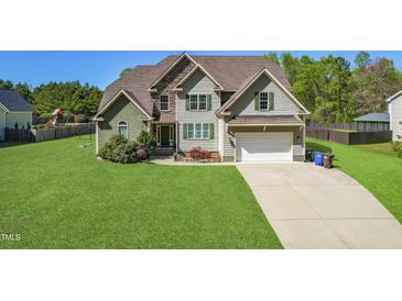 Charming two-story home with manicured lawn, attached garage, and beautiful landscaping at 7945 Parker Mill Trail, Fuquay Varina, NC 27526