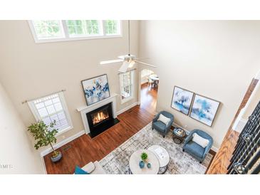 Bright living room boasts high ceilings, fireplace, hardwood floors, and an open concept design at 7945 Parker Mill Trail, Fuquay Varina, NC 27526