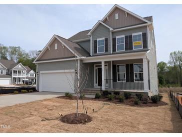 Charming two-story home with a two-car garage, front porch, and landscaped yard at 19 Grassland Dr, Garner, NC 27529