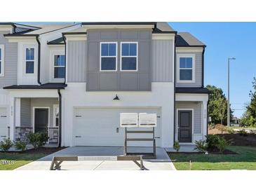 Two-story townhome with gray and white siding, two-car garage, and landscaping at 2000 Regal Dr # 88, Durham, NC 27703