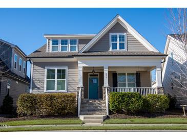 Charming two-story home with inviting front porch, manicured landscaping, and a bright blue front door at 213 Quarter Gate Trace, Chapel Hill, NC 27516