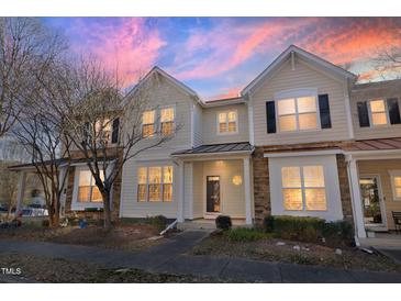 Two-story townhome with light beige siding, stone accents, and a charming front porch at 4108 Cherry Blossom Cir, Durham, NC 27713