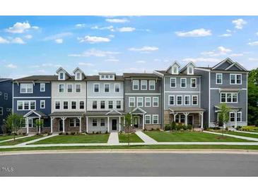 Charming street view of townhomes with well-manicured lawns and inviting entryways at 433 Rowe Way, Knightdale, NC 27545