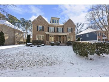 Brick two-story home with a snow-covered front yard at 109 Aspenridge Dr, Holly Springs, NC 27540