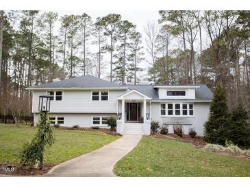 White charming one-story home with a well-manicured lawn at 128 Bruce Dr, Cary, NC 27511