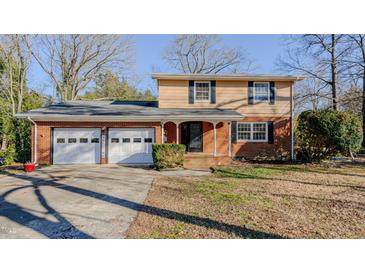 Brick ranch house with attached two-car garage and a well-manicured lawn at 3042 Marlborough Rd, Burlington, NC 27215