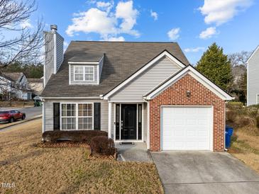 Gray siding house with brick accents, a two-car garage, and landscaping at 3838 Potecasi Dr, Raleigh, NC 27610