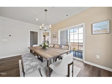 Bright dining room features a wood table with bench seating and access to a balcony at 602 Market Grove Dr # 200, Wake Forest, NC 27587