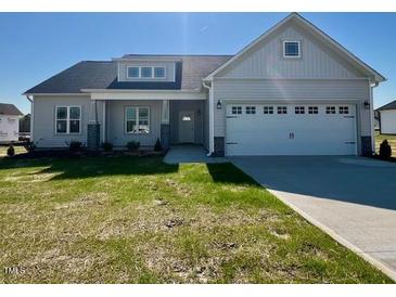 Charming single-story home featuring a well-manicured lawn and a two-car garage at 899 Olive Branch Dr, Smithfield, NC 27577