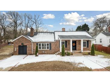 Brick ranch house with covered porch, landscaping, and a detached garage at 927 Bellvue St, Burlington, NC 27217