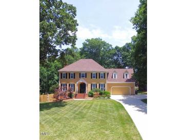 Charming two-story traditional home with lush lawn, mature trees and a two car attached garage at 12016 Pembridge Ln, Raleigh, NC 27613