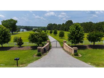 Gated driveway leading to a stately home on a sprawling, well-manicured lawn at 14425 Nc-96 N Hwy, Zebulon, NC 27597