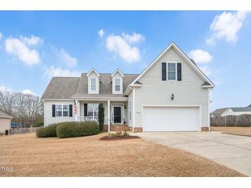 Suburban home with two-car garage and landscaped lawn at 1704 Little Drake Ave, Willow Springs, NC 27592