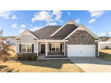 Two-story house with gray siding, stone accents, and a two-car garage at 256 Barbour Farm Ln, Four Oaks, NC 27524