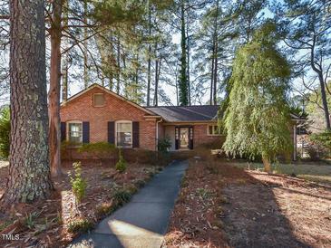 Brick ranch house with walkway, surrounded by mature trees at 5200 Newhall Rd, Durham, NC 27713