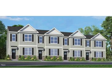 Exterior view of four attached townhouses with landscaping at 872 Old Tarboro Rd, Wendell, NC 27591