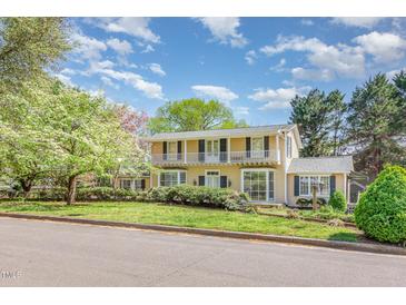 Charming two-story home with balcony, black shutters, and a lush front lawn at 110 E Orange St, Hillsborough, NC 27278