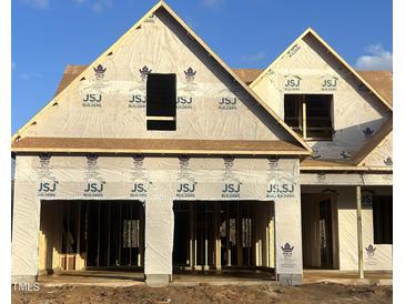 Two-story house under construction, featuring a large front porch and a three-car garage at 35 Hewitt Wds Dr, Clayton, NC 27527