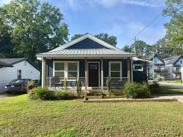 Charming single-story home boasts a covered front porch and well-maintained landscaping at 819 Cumberland St, Raleigh, NC 27610