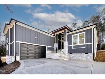 Modern gray house with white stone accents and a two-car garage at 110 Mohave Dr, Louisburg, NC 27549