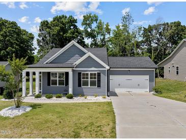 Charming single-story home boasts a well-manicured lawn, attached two-car garage, and welcoming entrance at 36 Mae Ct, Roxboro, NC 27573