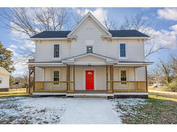 Two-story home with a red front door and wrap-around porch at 801 N Mebane St, Burlington, NC 27217