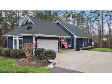 Exterior of a charming blue house with a white garage door and landscaping at 146 Buoy Dr, Henderson, NC 27537