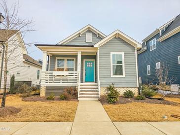 Gray craftsman style home with a teal door and white porch at 54 Cottage Way Way, Pittsboro, NC 27312