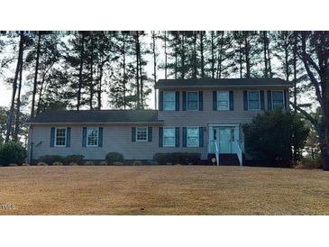 Two-story house with light pink siding, and a grassy yard at 7607 Divot Dr, Sanford, NC 27332