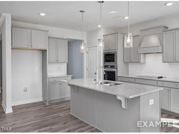 Modern kitchen with island, stainless steel appliances, and gray cabinets at Tbd0076 Priming Way, Angier, NC 27501