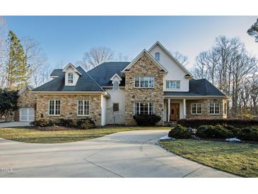 Elegant two-story home with stone accents and a large driveway at 1313 Enderbury Dr, Raleigh, NC 27614