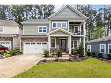 Two story home with stone and shingle accents, two car garage, and landscaped lawn at 172 Cotten Dr, Morrisville, NC 27560