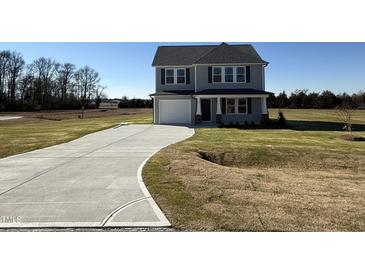 Two-story house with gray siding, a white door, and a curved driveway at 25 Harvest Hills Ln, Dunn, NC 28334