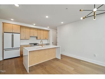 Bright kitchen features stainless steel appliances, light wood cabinets, white countertops, and a kitchen island at 29 Enterprise St # 309, Raleigh, NC 27607