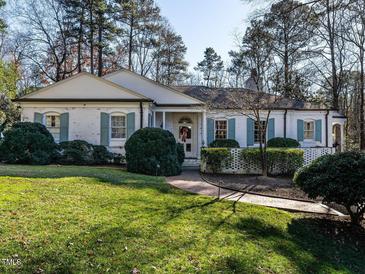 Brick house with a landscaped lawn and walkway at 3500 Chaucer Pl, Raleigh, NC 27609