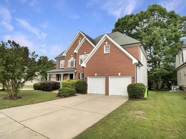 Charming two-story brick home with a well-manicured lawn and attached two-car garage at 408 Froyle Ct, Rolesville, NC 27571