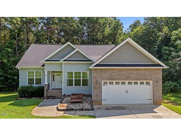 Charming single Gathering home featuring a brick and vinyl exterior, attached two car garage, and well maintained lawn at 46 Trusting Ln, Middlesex, NC 27557