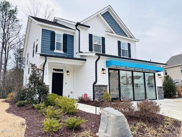 Two-story home with white siding, blue accents, and landscaping at 5112 N River Sand Trl, Raleigh, NC 27604