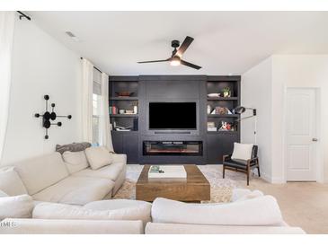 Stylish living room featuring a modern entertainment center with built-in shelves and an electric fireplace at 57 Duchess Ave, Franklinton, NC 27525