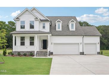 Beautiful two-story home with a three-car garage and covered front porch at 92 Frost Meadow Way, Lillington, NC 27546