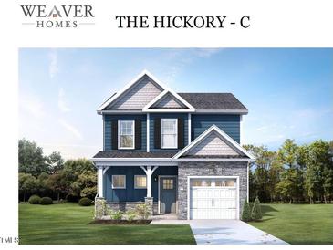 Two-story home with blue siding, white trim, and a two-car garage at 4214 Darroch Rd, Lillington, NC 27546