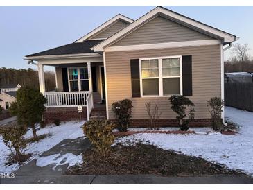 Tan house with a white porch and black shutters, snow on the ground at 5430 Neuse Ridge Rd, Raleigh, NC 27610