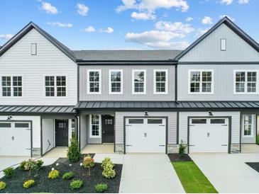 Three-unit townhome building with gray siding, black accents, and attached garages at 609 Marshskip Way, Rolesville, NC 27571