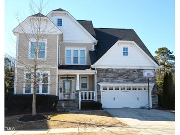 Two-story house with stone accents, a large garage, and a basketball hoop at 7713 Stonehenge Farm Ln, Raleigh, NC 27613