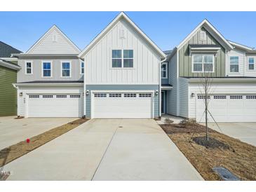 Charming new construction home showcasing a well-manicured lawn and a spacious two-car garage at 911 Montague Ave, Durham, NC 27703