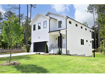 Modern two-story home with white siding, black accents, and a grassy lawn at 916 Ardmore Dr, Durham, NC 27713