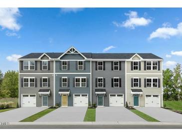 Four-unit townhome building with attached garages and neutral color palettes at 256 Grand Silo Rd, Garner, NC 27603