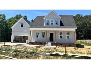 New two-story home with gray siding, a front porch, and an attached two-car garage at 404 Brodie Rose Landing Way, Smithfield, NC 27577
