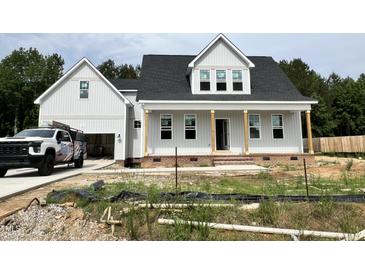 Charming two-story home with gray siding, black roof and welcoming front porch, perfect for relaxing at 404 Brodie Rose Landing Way, Smithfield, NC 27577