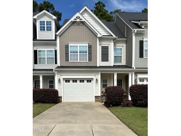 Two-story townhome with gray siding, white garage door, and landscaping at 166 Gulley Glen Dr, Garner, NC 27529